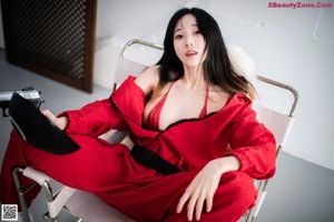 A woman in a red bikini sitting on the floor.