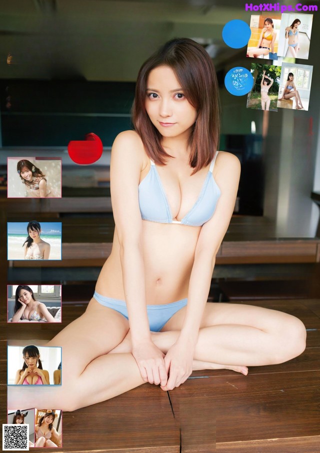 A woman in a blue bikini sitting on a wooden floor.
