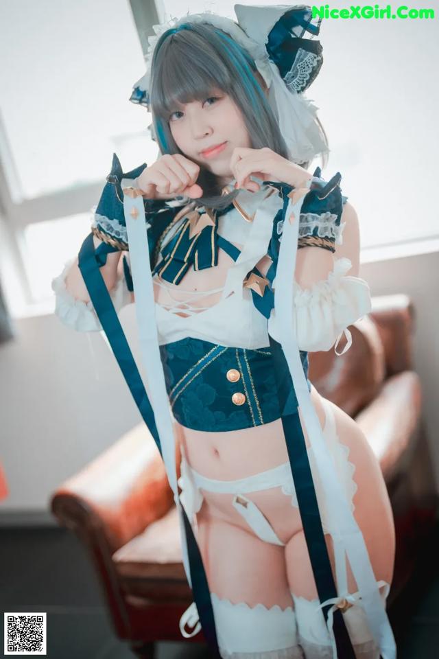 A woman in a maid outfit posing for a picture.