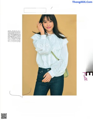 A woman in a white shirt and beige pants posing for a magazine.