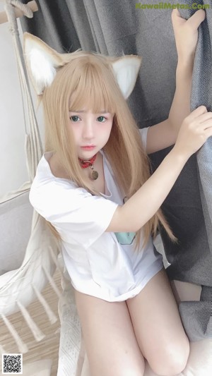A woman with long blonde hair wearing a cat ears headband.