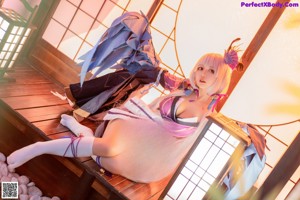 A woman in a pink and blue outfit sitting on a bench.
