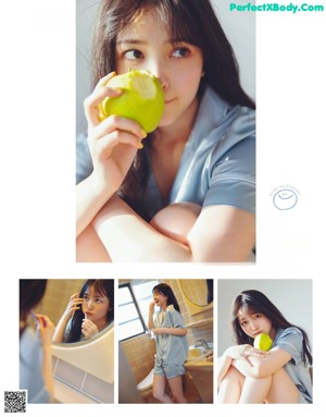 A woman sitting at a table eating a piece of bread.