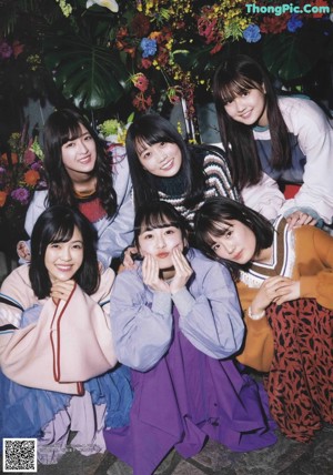A group of young women posing for a photo in front of a wall.