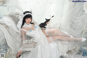 A woman in a wedding dress holding a bouquet of flowers.