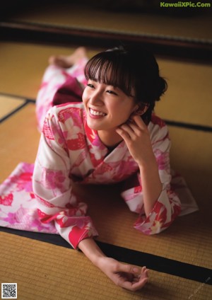 A woman laying on a tatami mat in a room.