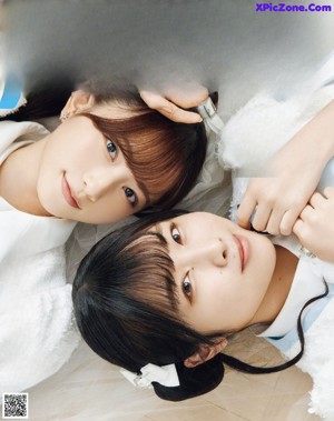 A couple of young women sitting next to each other.