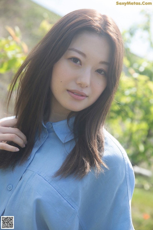 A woman in a blue shirt posing for a picture.