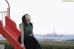 A woman standing on top of a balcony next to a railing.