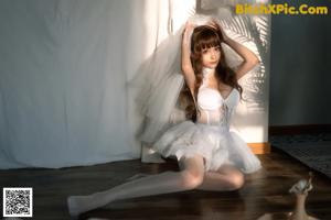 A woman wearing a white lingerie with a white bow.