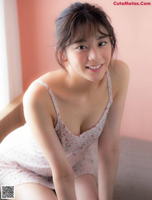 A woman laying on a bed eating a strawberry.