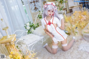 A woman dressed as a nurse sitting on a white chair.