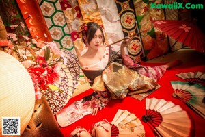 A woman in a kimono holding an umbrella in a city street.