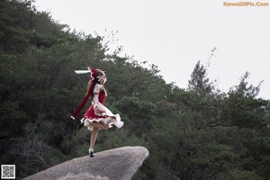 A woman in a red and white dress holding a sword.