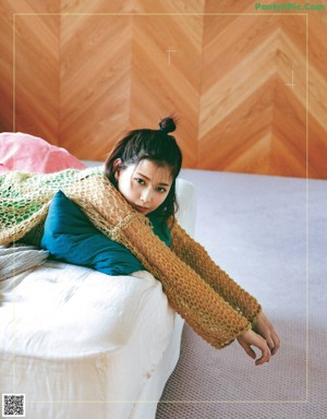 A woman laying in bed with her head on a pillow.