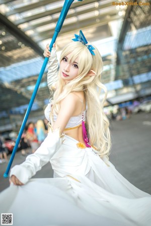 A woman in a white dress holding a blue wand.