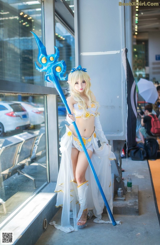 A woman in a white dress holding a blue sword.