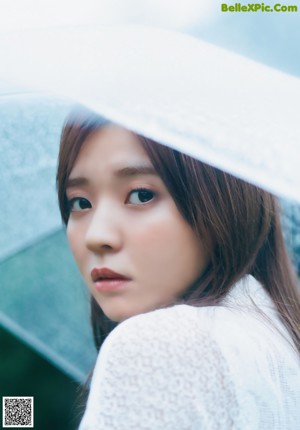 A woman with long brown hair is looking away from the camera.