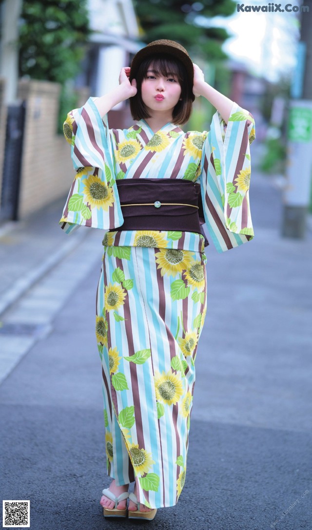 A woman in a kimono is standing on the street.