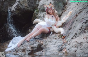A woman in a white dress with a white fox on her back.